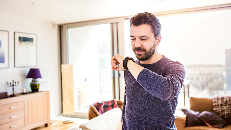 Man controlling home devices via his watch