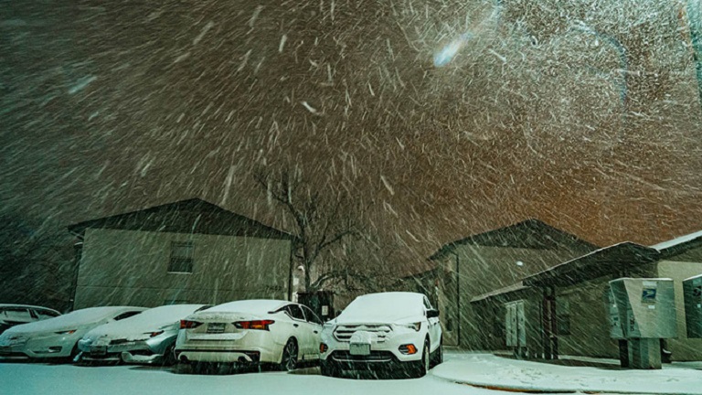 Cars and houses in a snowy night