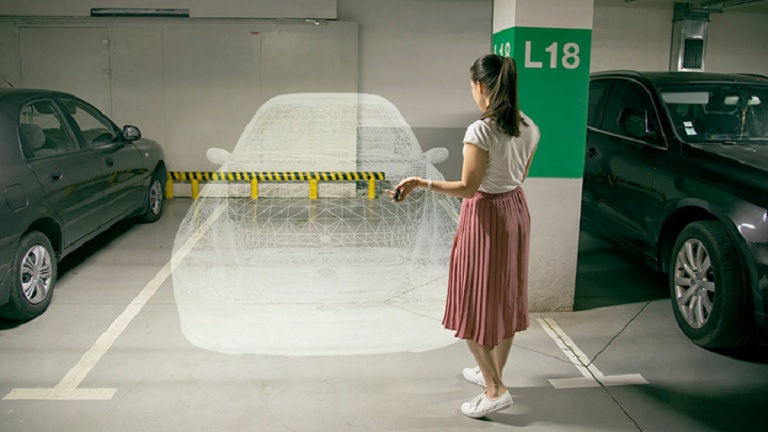 Parking garage, woman standing in front of empty spot with a digital outline of a car