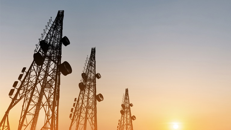 Three communication towers at dawn