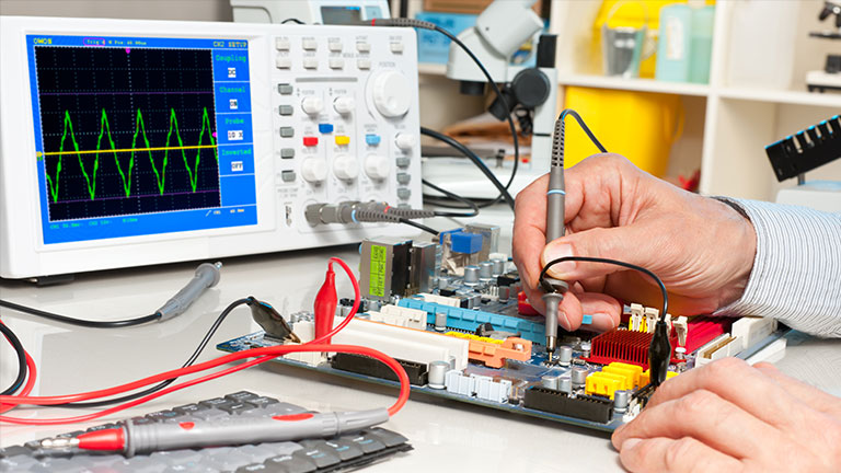 Engineer using an oscilloscope to test a circuit