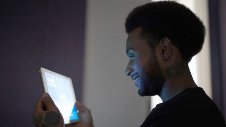 Image of a man looking at a tablet; an example of smart building technology