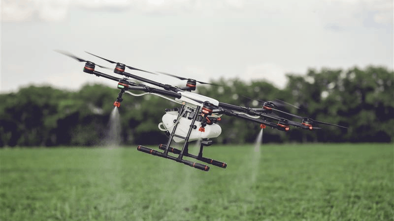 Drone spraying pesticides over crops